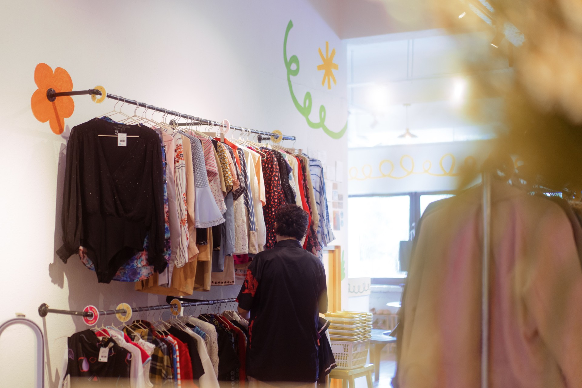 A Person Looking Through Secondhand Clothes at Local Thrift Shop